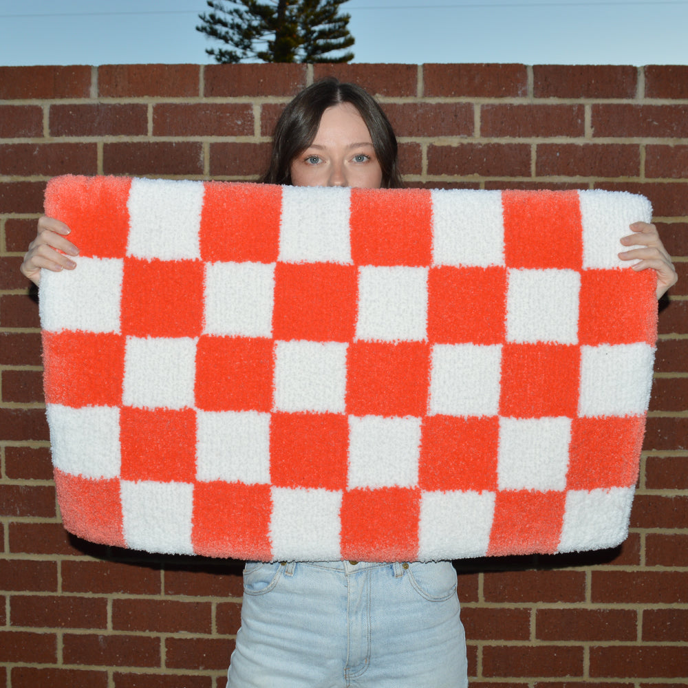 Woman Holding Casaprima Blood Orange & White Checkerboard Rug