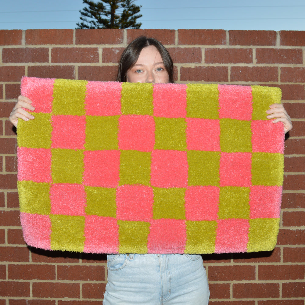 Woman Holding Casaprima Green & Pink Checkerboard Rug