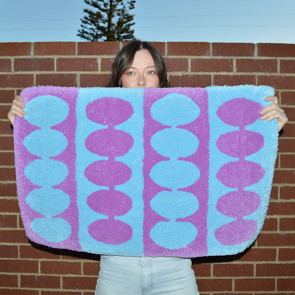 Woman Holding Casaprima Oval Stripe Rug
